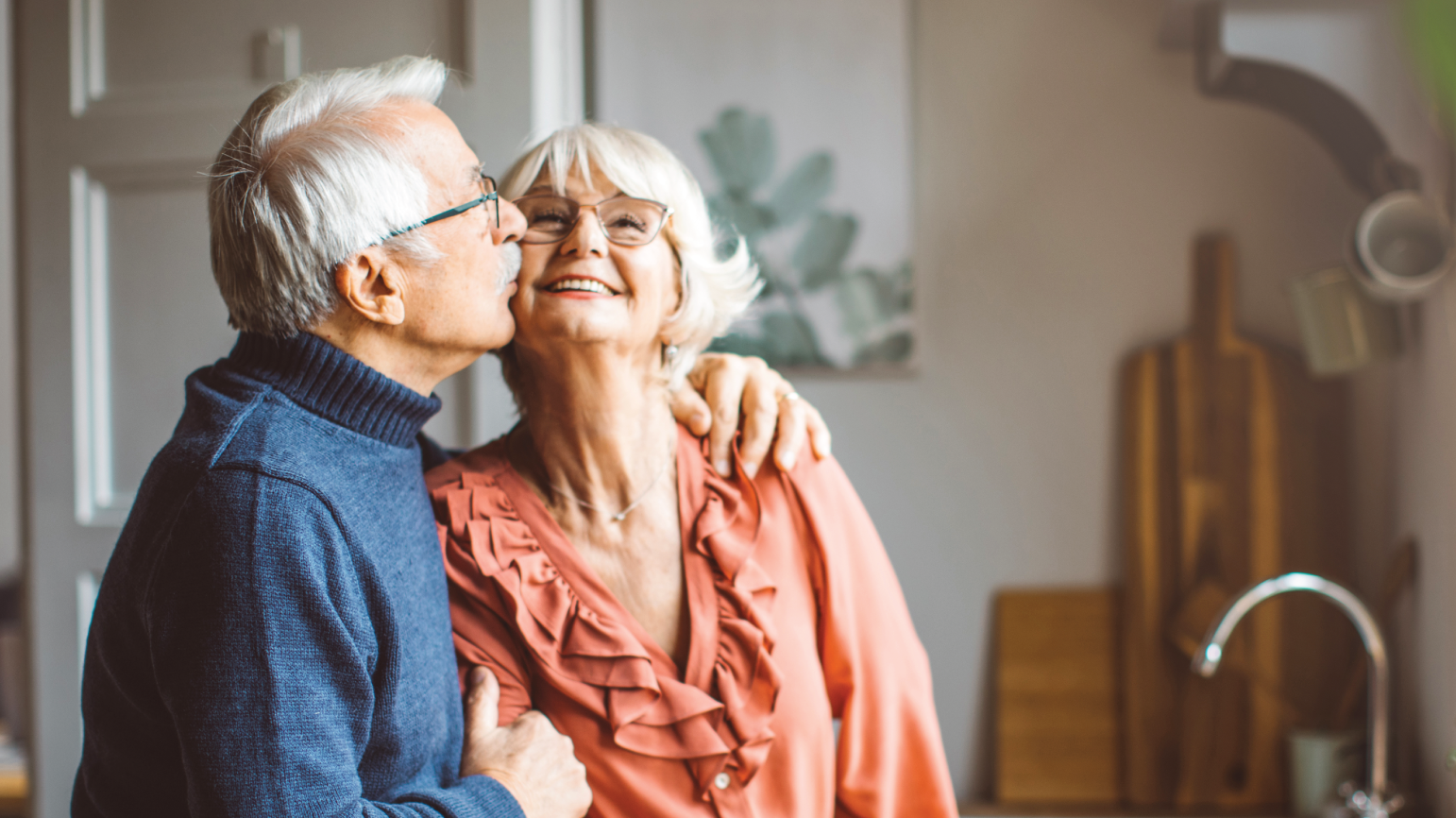 A senior man, giving his pretty senior wife a kiss on the cheek